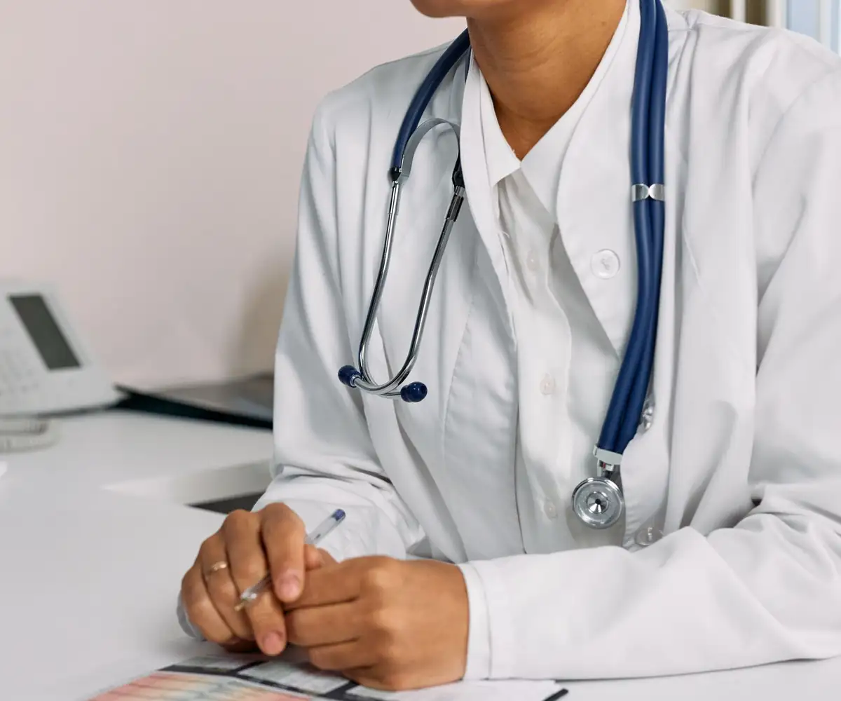 A doctor at her desk beside the office phone