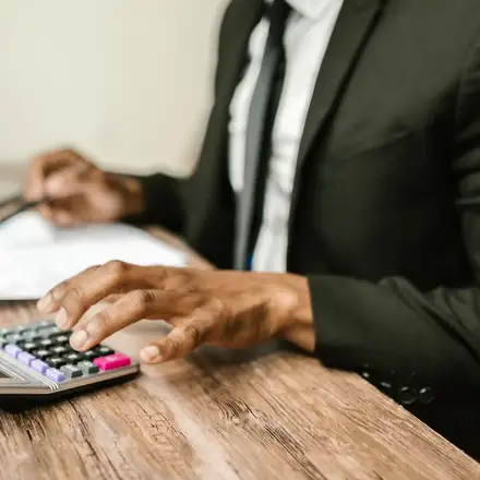 A billing specialist working through claims with a calculator