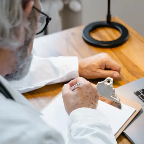 A physician writing up a visit at his desk