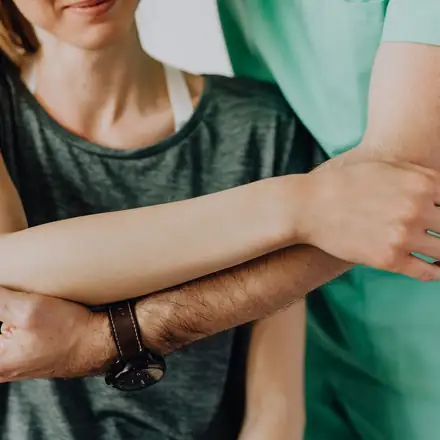 A chiropractor stretching a patient’s shoulder