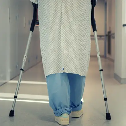 A patient walking with crutches