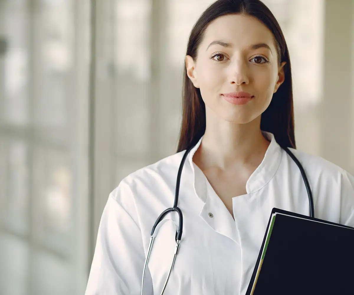 A smiling young physician holding her notebook