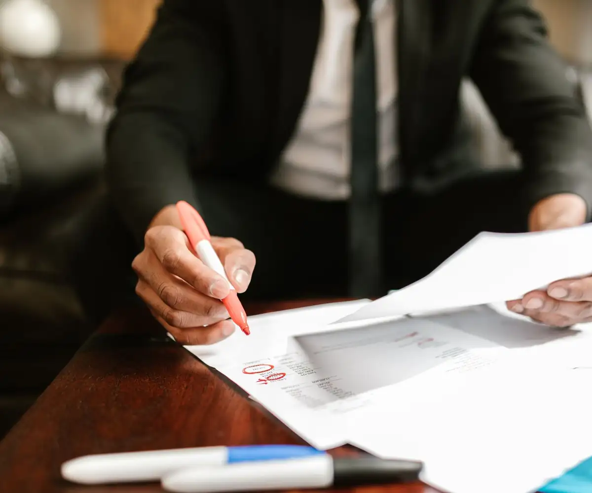 A reviewer marking up a claim printout with a red pen