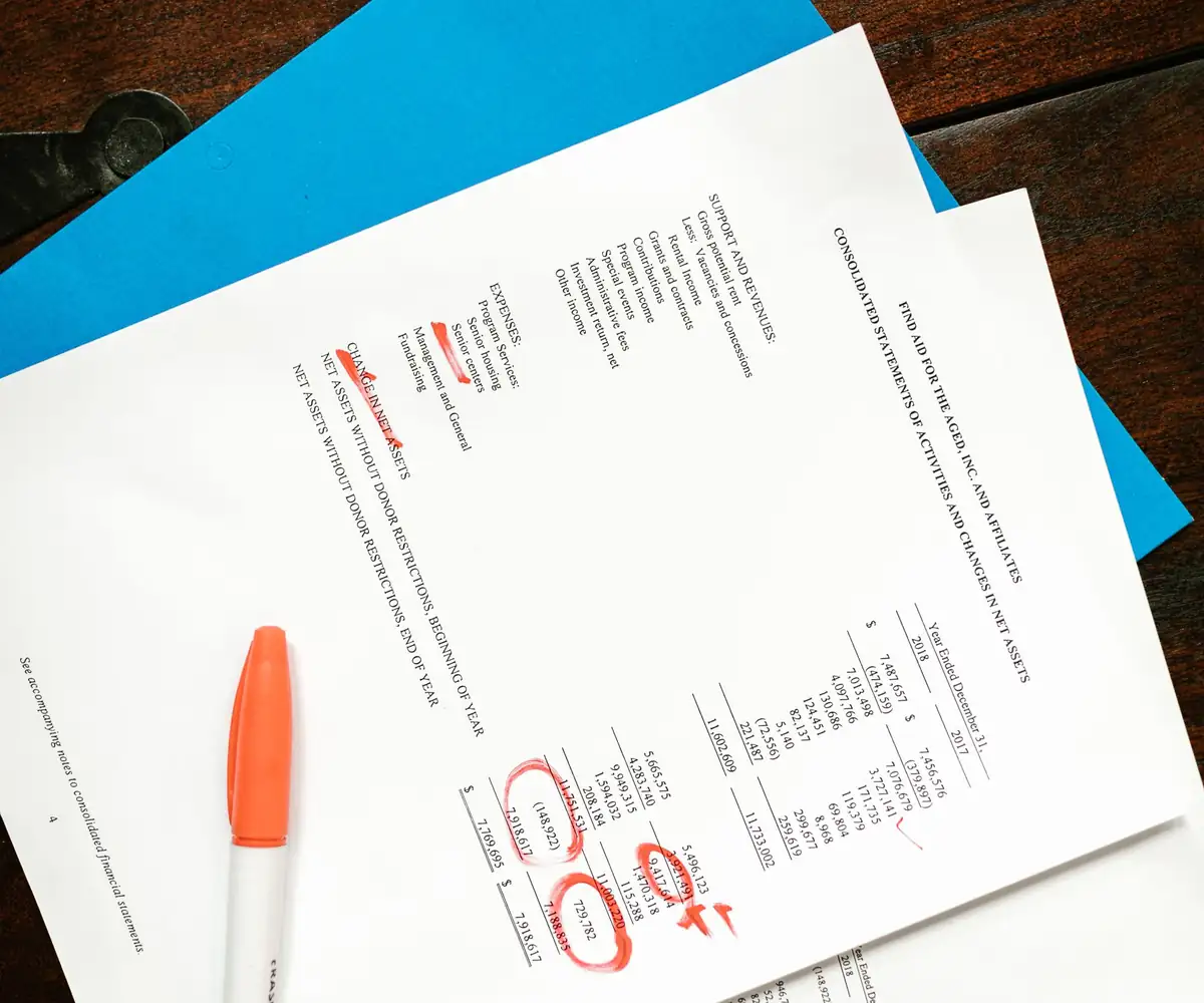 Printed claim forms marked in red on a desk
