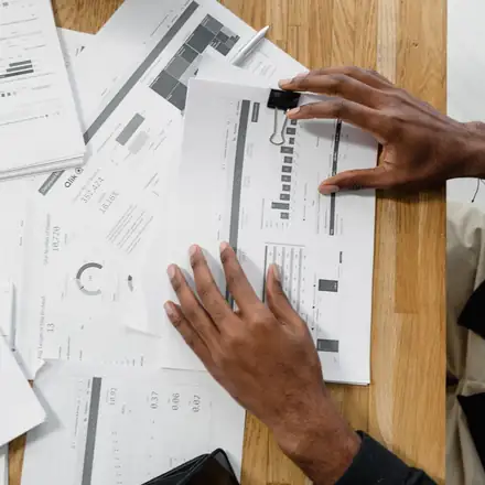Hands sorting claim papers across a desk