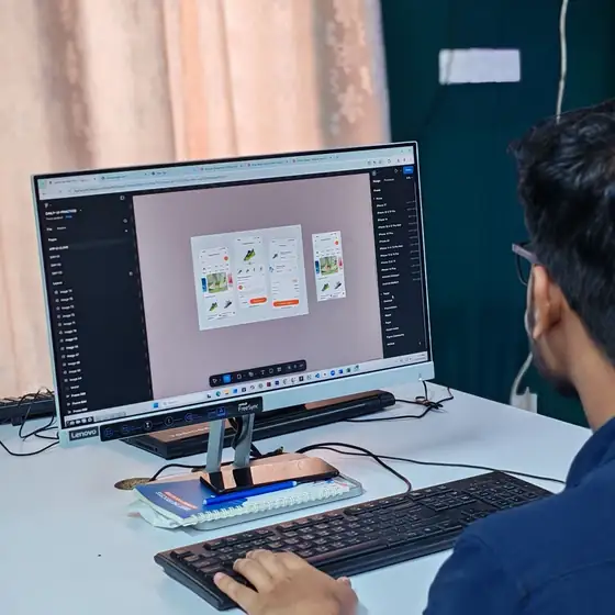 A designer building a website layout on a desktop computer