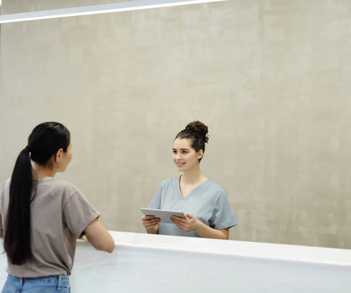 A receptionist checking a patient in at the front desk