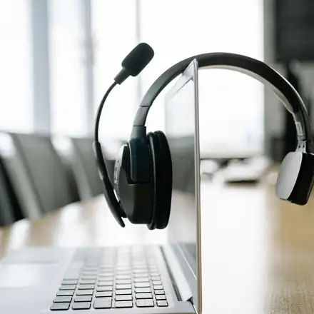 A headset hanging on a laptop screen