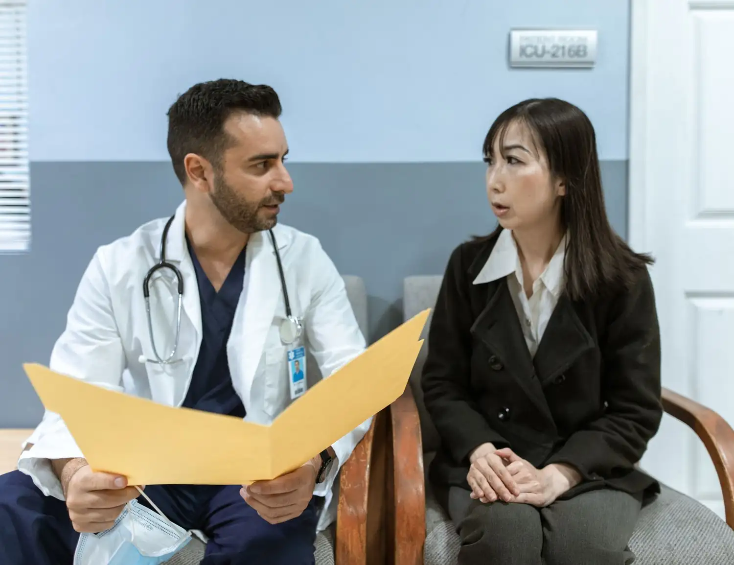 A doctor and a practice manager reviewing a folder together