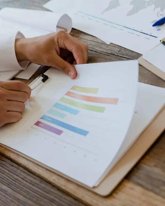 Hands reviewing a report full of charts