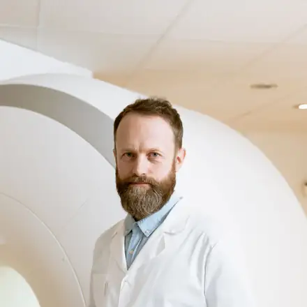 A physician beside an MRI scanner