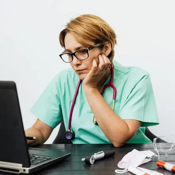 A nurse practitioner working at her laptop