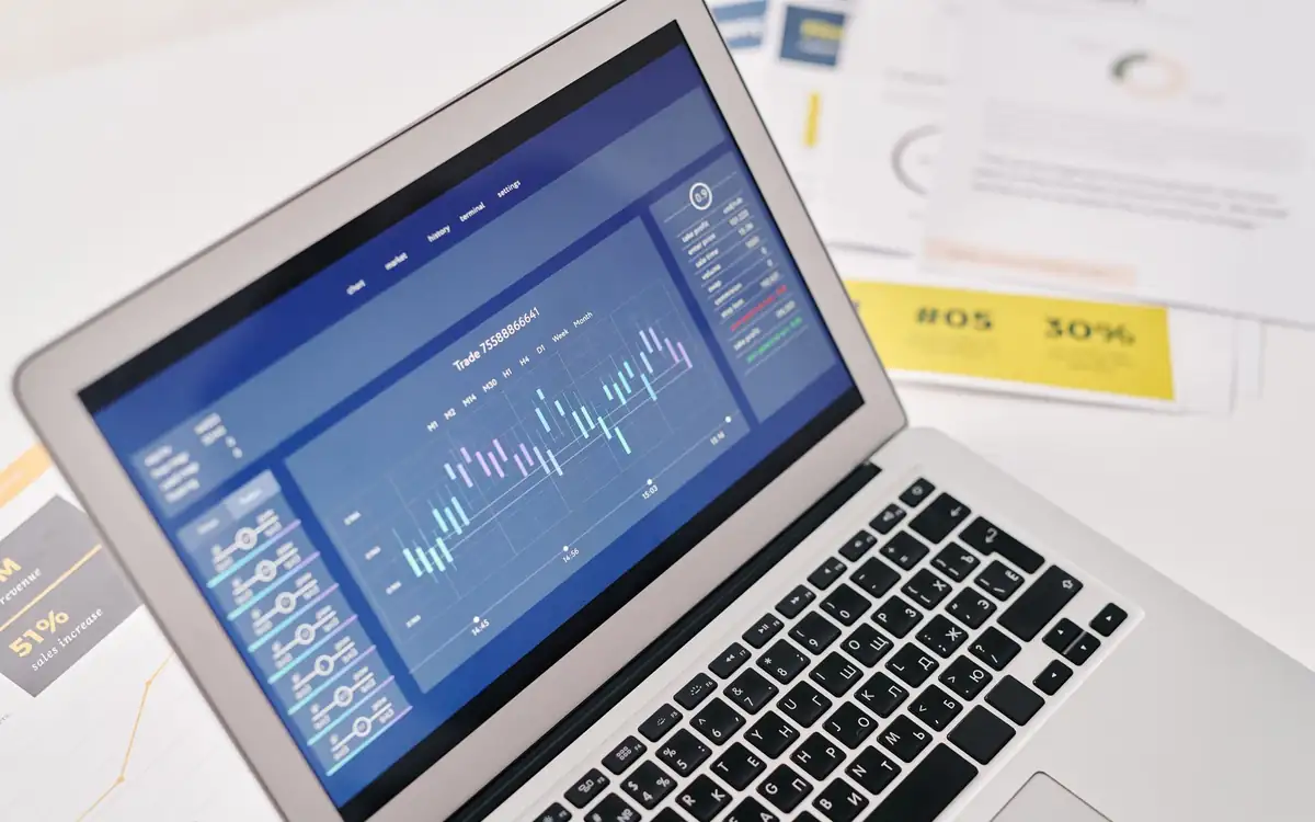 A laptop showing a dashboard of charts