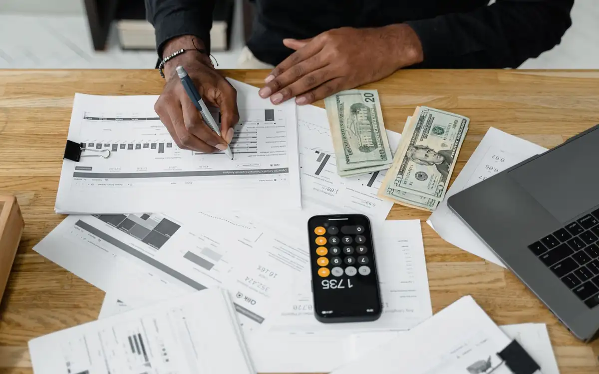 Paperwork, cash and a calculator on a desk