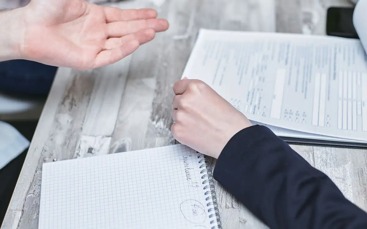 Hands going through an application at a desk