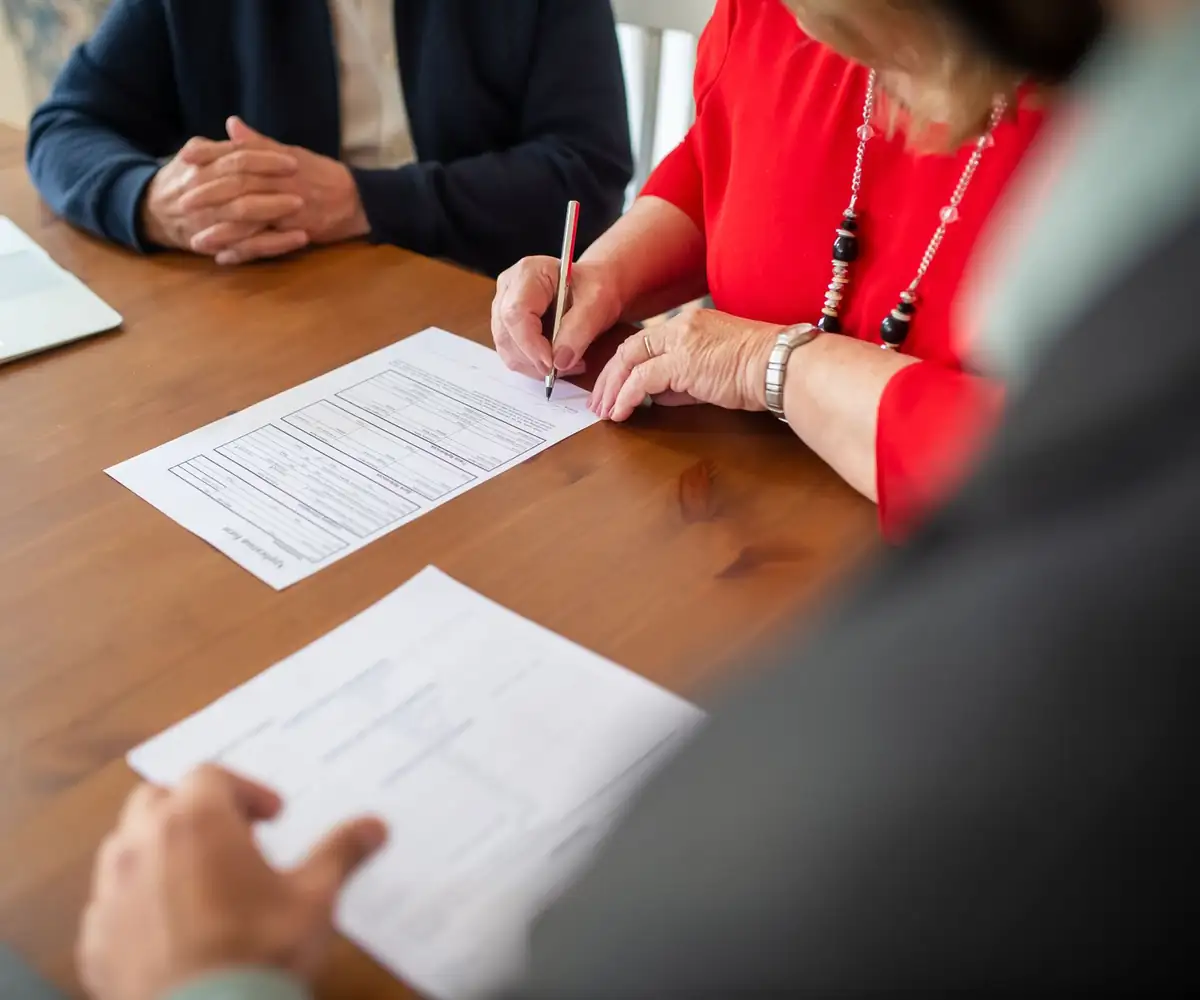 Two people filling in forms at a table