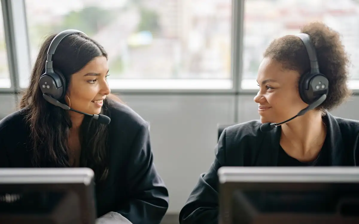Two assistants with headsets talking between calls