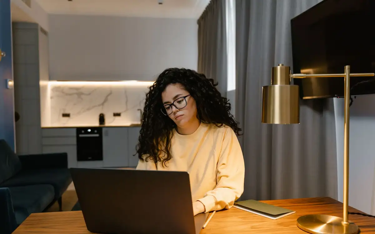 An assistant working on a laptop at a home desk