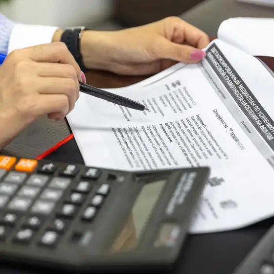 Hands checking figures with a calculator