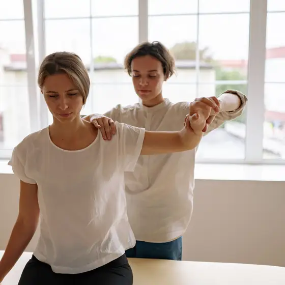 A therapist stretching a patient’s arm and shoulder