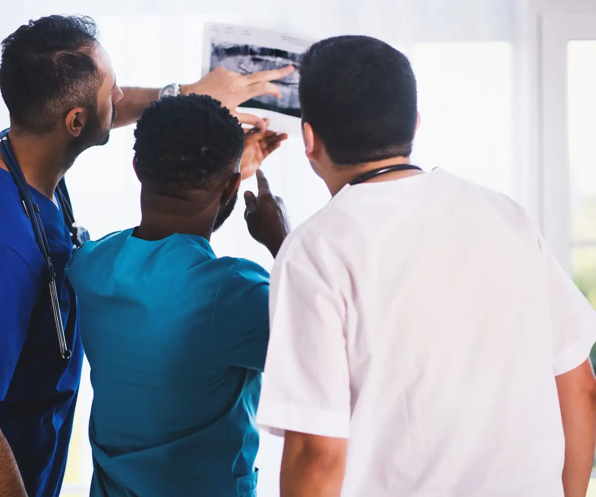 Three clinicians studying an X-ray together