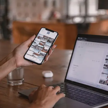 Social media posts being edited on a phone and a laptop