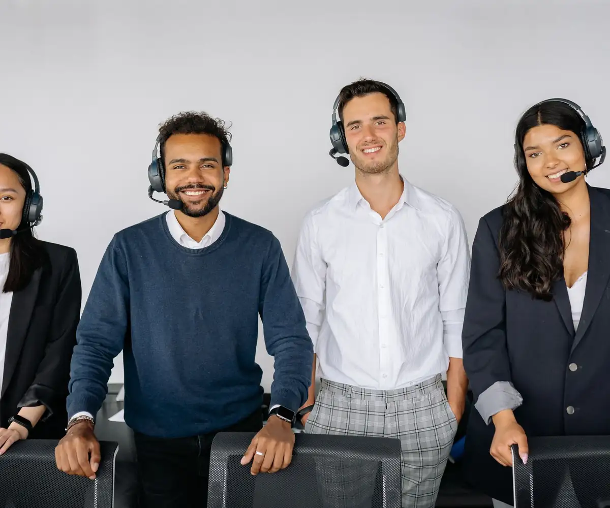 A smiling team of billing specialists wearing headsets
